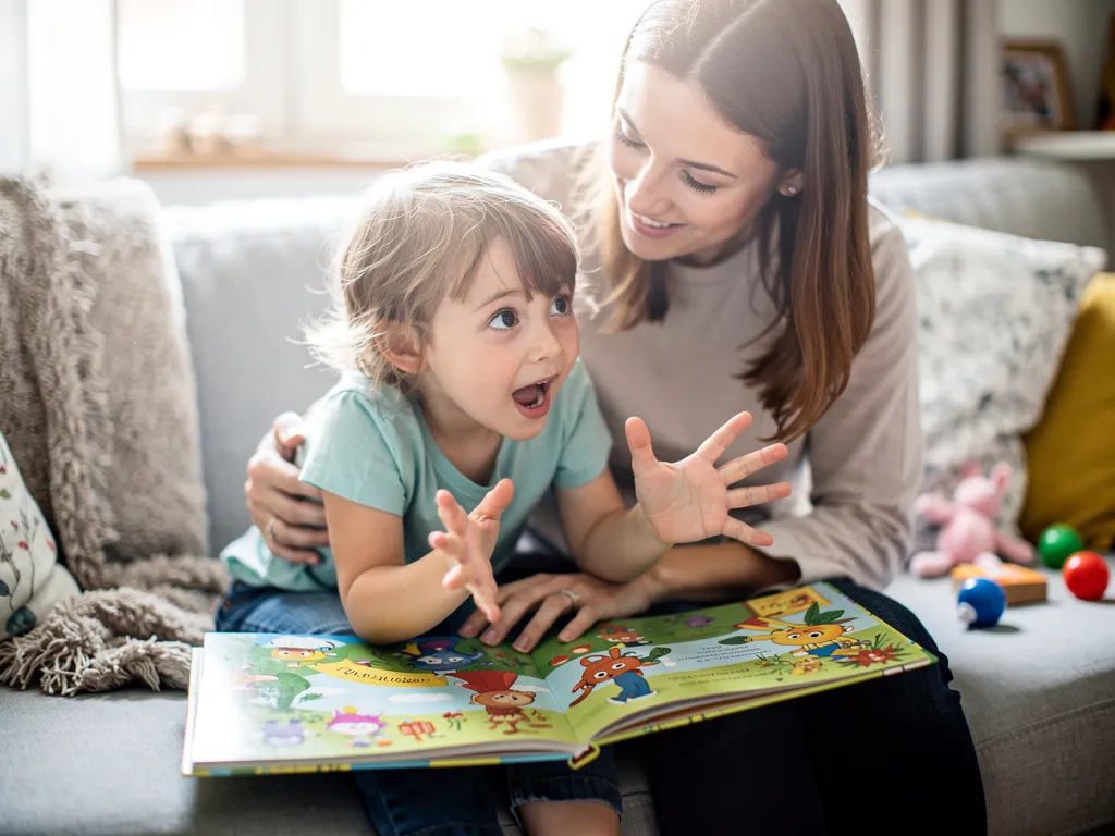 A parent and child sitting together, happily looking at a personalized story on a tablet